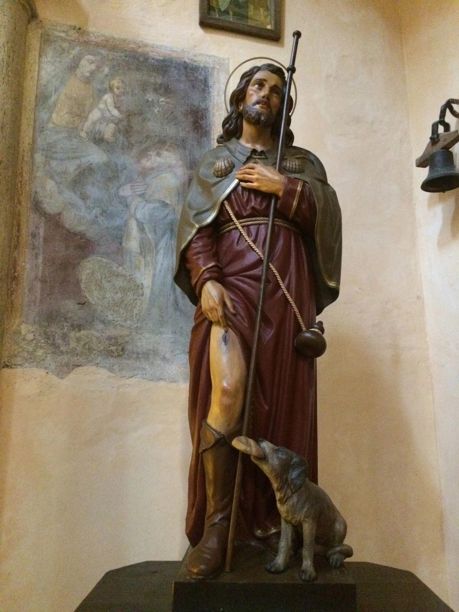 Каноническая статуя святого Рокко — с чумной язвой на ноге и собакой — в старейшей церкви города (XII век)